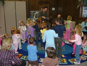 Actor Nick Piper winds up kids' motors while reading <em>So Sleepy Story</em> at the Washington County Library in Abingdon, Va. (Photo by Debra McCown|Bristol Herald Courier)