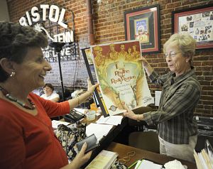 Bristol resident Carol Bannish, left, buys tickets and posters from Mary Geiger at the Bristol Rhythm & Roots Reunion office. (Photo by Earl Neikirk | Bristol  Herald Courier)