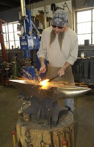 Greg Shaffer hammers a piece of metal, sending out a shower of sparks at his shop in Bristol, Va. (Earl Neikirk | Bristol Herald Courier)