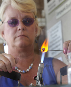 Robbie Gentry works on a glass Christmas tree bead at the Virginia Highlands Festival in Abingdon. (Photo Earl Neikirk/Bristol Herald Courier) 