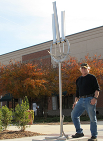 Dr. Marvin Tadlock is shown with his unique sculpture, "Trinity."