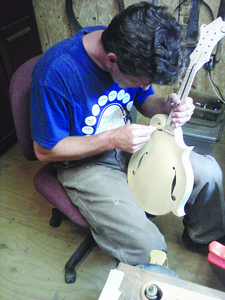 Will Parsons builds a mandolin in his workshop.