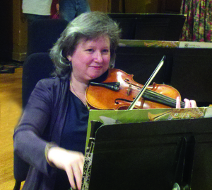 Dr. Theresa Lura plays violin with two orchestras and a string quartet. (Photo by Jim Benelisha)