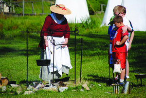 A living historian conducts a cooking demonstration at the Abingdon Muster Grounds.