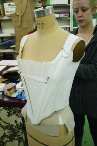 Ashley Campos fits an actress's corset to a dress form.