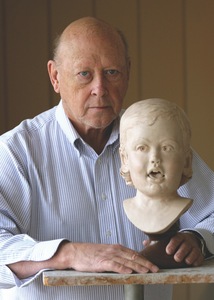 Lynn Price is seen here with one of his sculptures of a child.