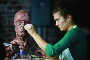 Maria Willison works on one of her figurative sculptures. (photo by Samuel Burns)