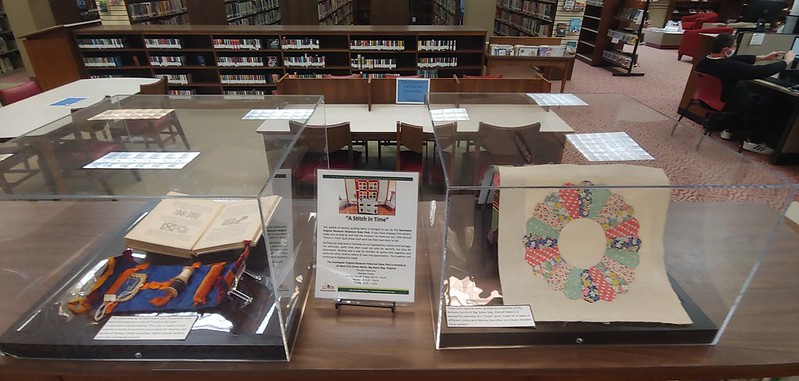 'Stitch in Time' exhibit features a collection of vintage quilt squares and sewing items.