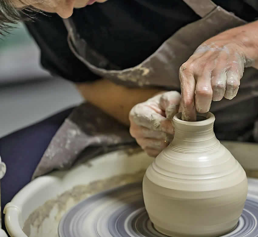 Potter and teacher Jean Ann Savery works clay on a potters wheel at Nature Speaks Pottery Studio.