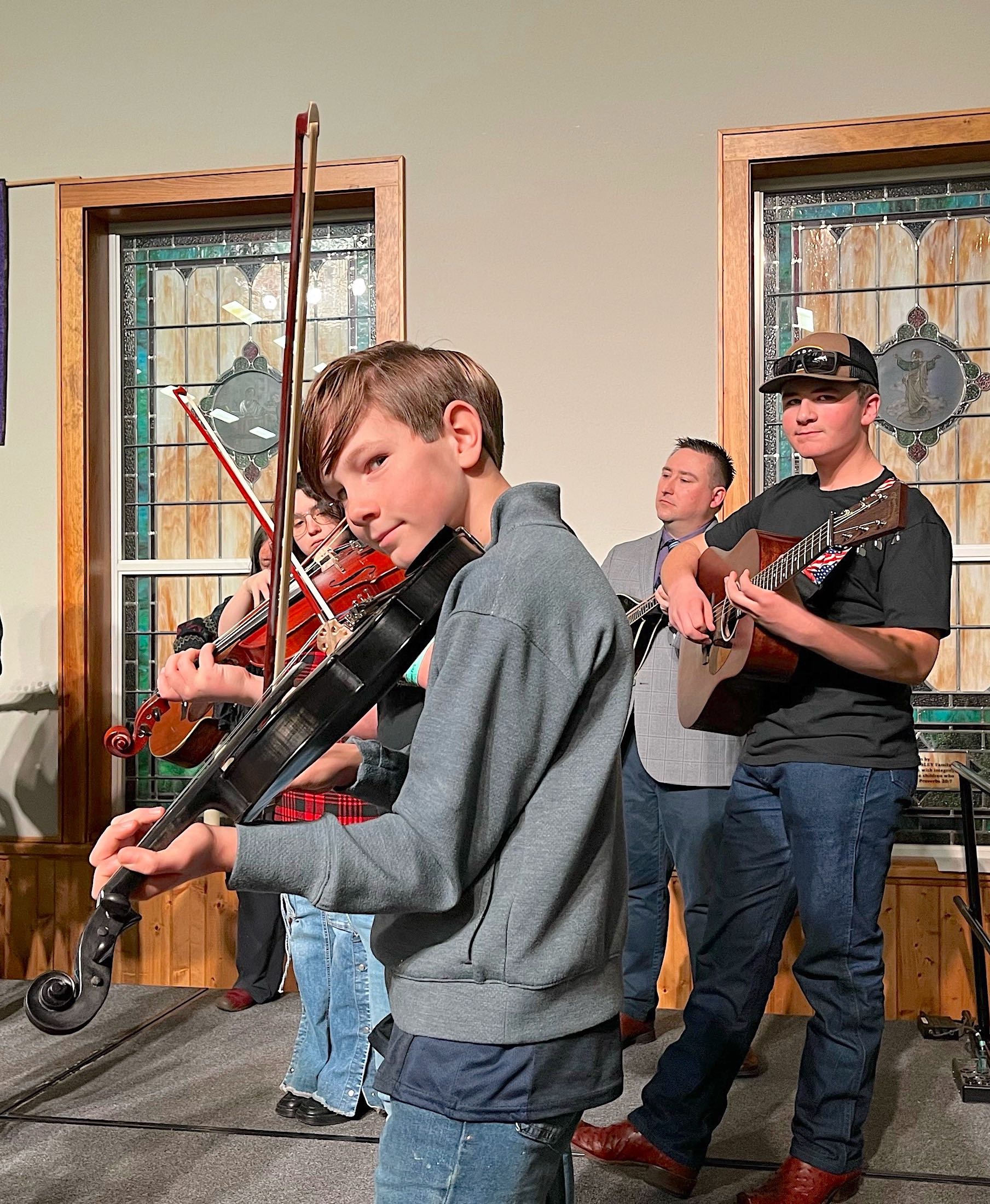 Uriah Visser and other JAM fiddlers prepare to perform with instructors Zane Lewis (guitar) and Mich